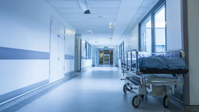 long corridor in a hospital with a hospital bed on the side and Bosch automatic fire detector on the ceiling