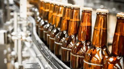 A line of beerbottles in a factory on a conveyor belt