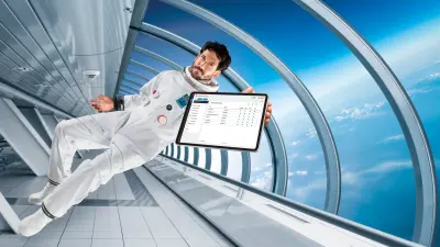 Man and woman dressed in working clothes looking at a tablet