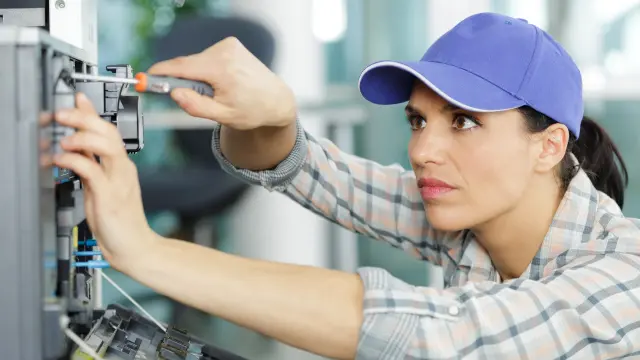 A woman doing maintenance on a fire alarm system