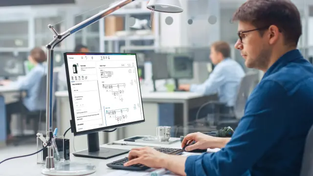 a man is sitting front of a PC and design a system